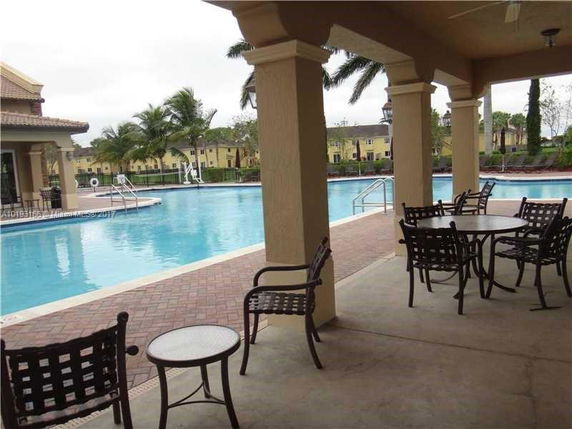 Outdoor swimming pool area with patio seating.