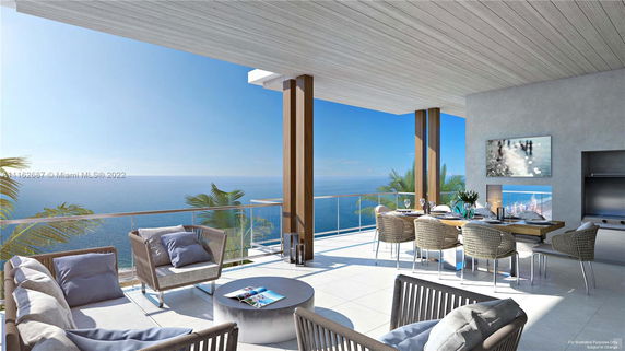 Balcony with outdoor furniture overlooking the ocean.