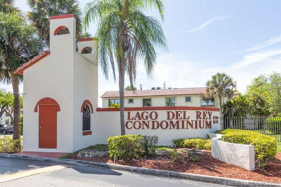 Front view of a condominium building with a sign reading 'Lago Del Rey Condominium'.