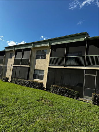 Front view of a multi-story building with screened balconies.