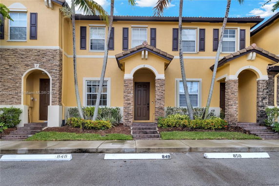 Front view of a townhouse with two stories and a brown door.