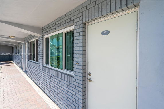 Exterior view of a building with brick walls and a door labeled 107.