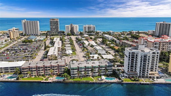 Aerial view of a coastal area with multiple residential buildings and the ocean in the background.