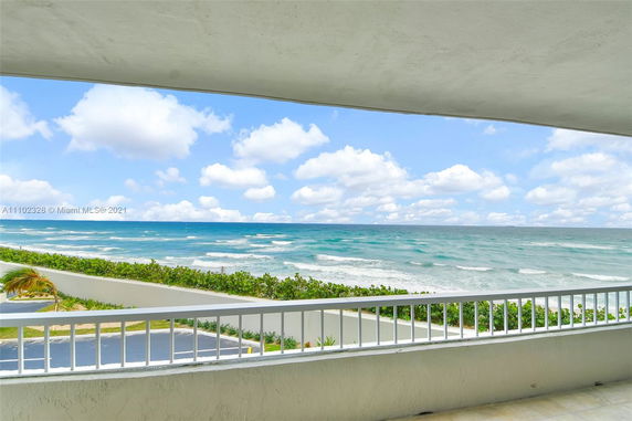 Panoramic view of ocean and sky from a building balcony.