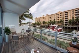 Balcony view overlooking a waterway with a boat and buildings in the background.
