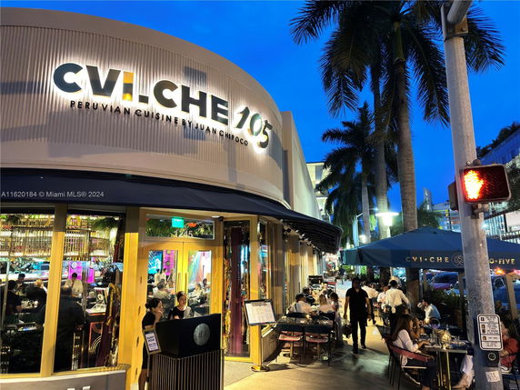 Front view of a restaurant with a prominent sign and outdoor seating area.