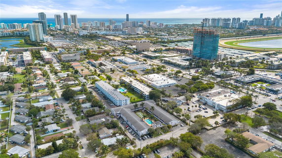 Aerial view of a cityscape with multiple buildings and a distant coastline.