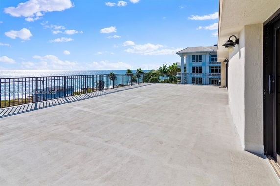 Expansive rooftop area with ocean view and railings.
