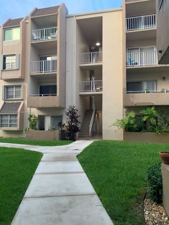 Front view of a multi-story apartment building with balconies.