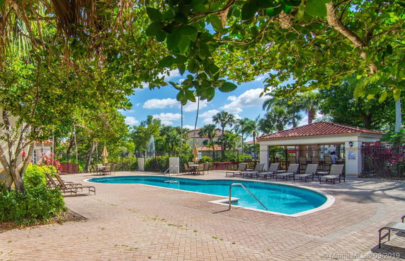 Outdoor area with a swimming pool and seating area surrounded by trees.