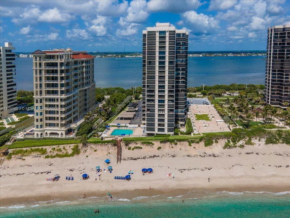 View of tall condominium buildings near a beach and a body of water.