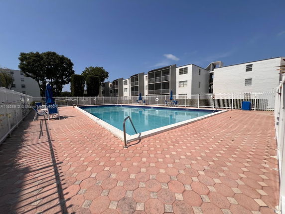 Outdoor swimming pool area with surrounding apartment buildings.