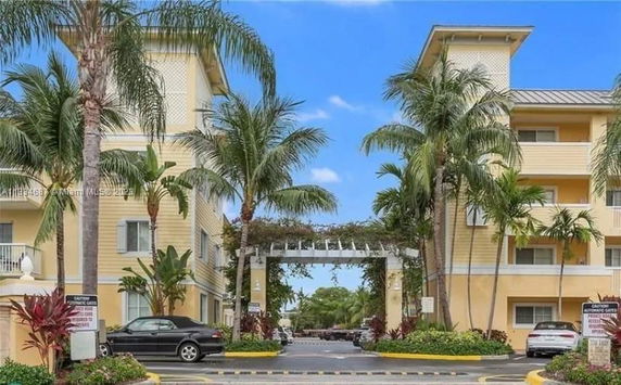Front view of a multi-story residential building with palm trees.