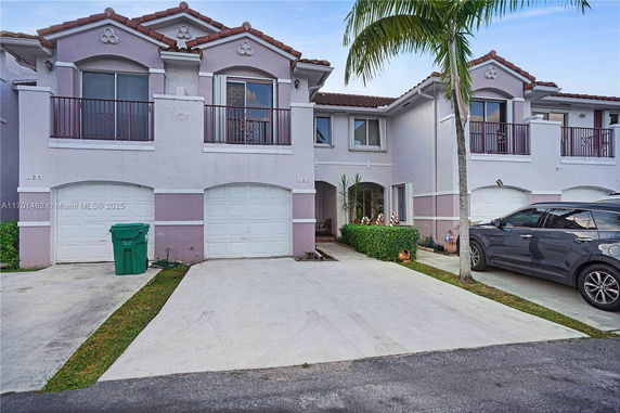 Front view of a two-story townhouse with garages and balconies.