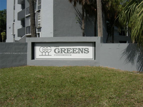 Front view of a condominium building with signage.