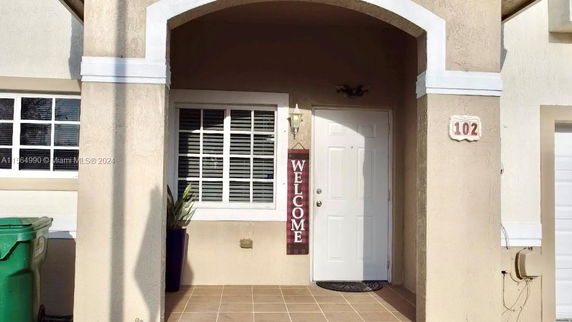 Front view of a house entrance with an arched doorway.