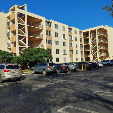Front view of a multi-story apartment building with balconies.