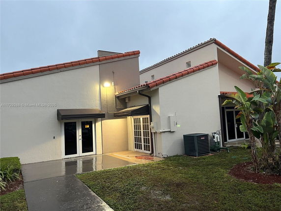 Front view of a house with a sloped roof and awning over doors.