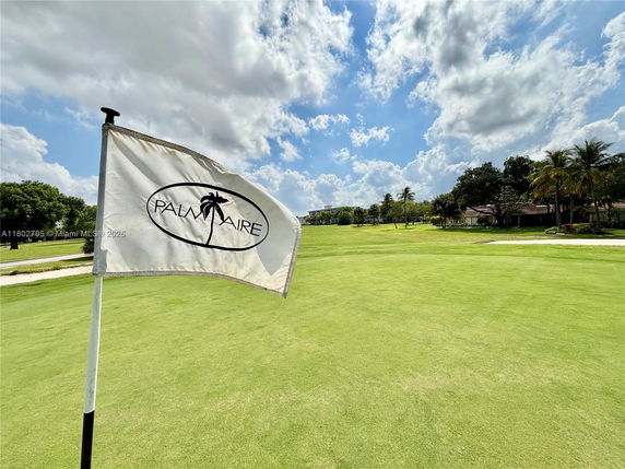 View of a golf course with a flag labeled 'PALM AIRE'.