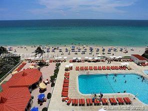 Panoramic view of a beachfront area with a swimming pool and sun loungers.