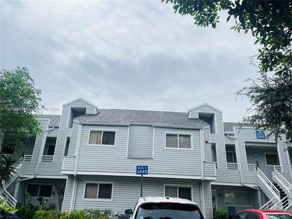 Front view of a multi-story residential building with stairs.