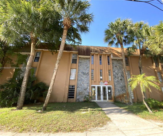 Front view of a multi-story building with stone and stucco facade.