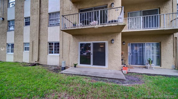 View of a multi-story residential building with balconies and sliding glass doors.