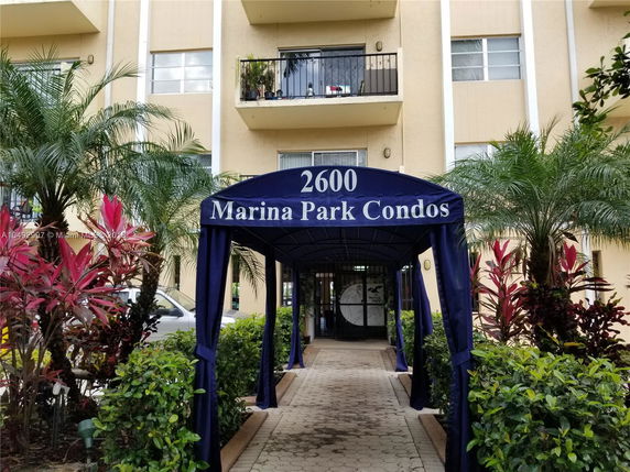 Front view of a multi-story condominium building with a covered entrance canopy.