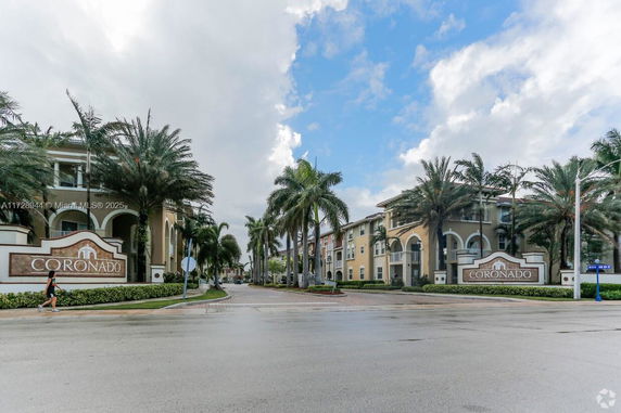 Front view of multiple residential buildings with palm trees.