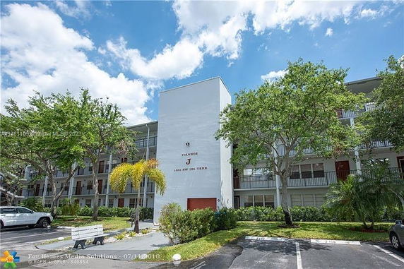 Front view of a multi-story residential building with a simple facade and balconies.