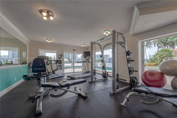 Interior view of a gym with various fitness equipment and large windows.