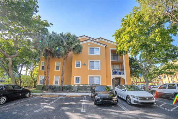 Front view of a three-story orange apartment building with balconies.