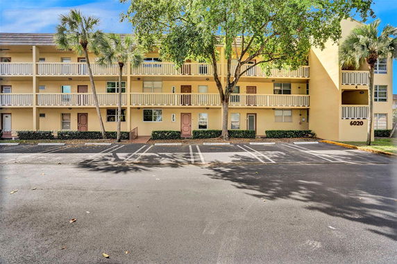 Front view of a three-story building with parking spaces in front.
