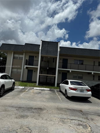Front view of a two-story building with parking spaces in front.