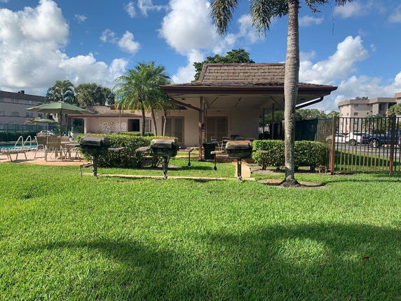 Backyard view with a patio, outdoor grills, and a lawn.