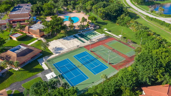 Aerial view of a recreational area with tennis courts and a swimming pool.