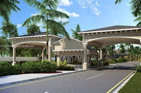 Front view of a gated entrance with an arch structure and palm trees.