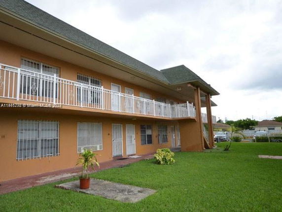 Front view of a two-story building with a balcony and orange exterior.