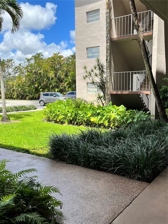 View of a building with balconies and surrounding greenery.