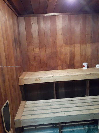 Interior view of a wooden sauna room with benches.