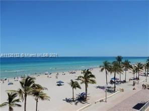 Beachfront view with palm trees and ocean.