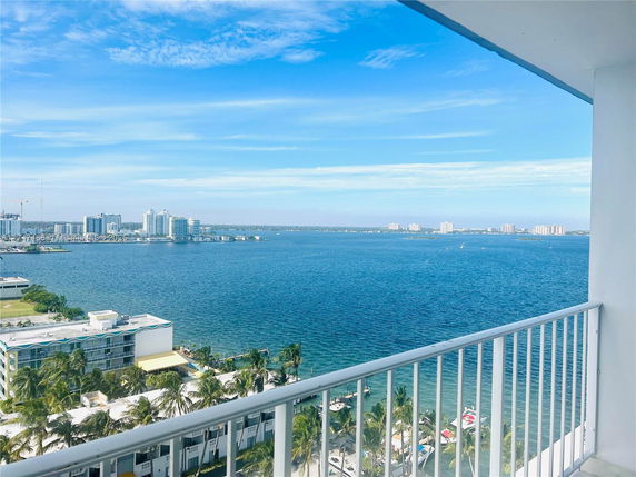 Panoramic view from a balcony overlooking a body of water and distant cityscape.