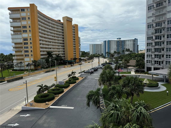 View of multiple mid-rise residential buildings in an urban setting with surrounding roads and greenery.