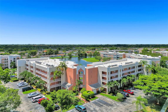 Front view of a multi-story residential building with parking area.