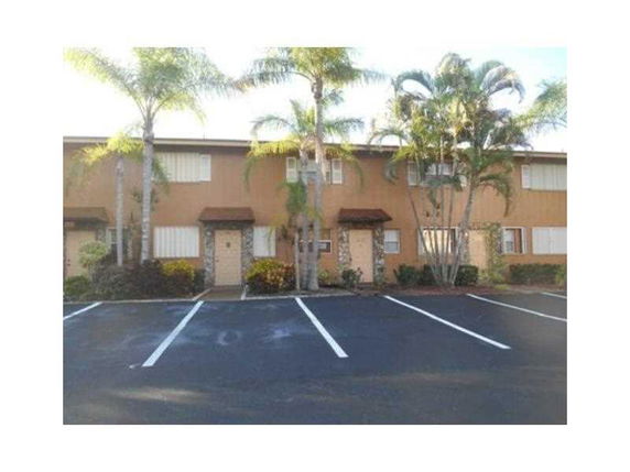 Front view of a two-story building with a parking area in front.