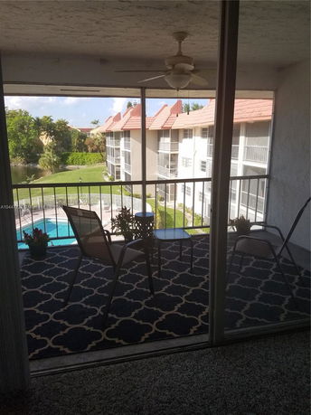 Balcony view overlooking a swimming pool and surrounding apartment buildings.