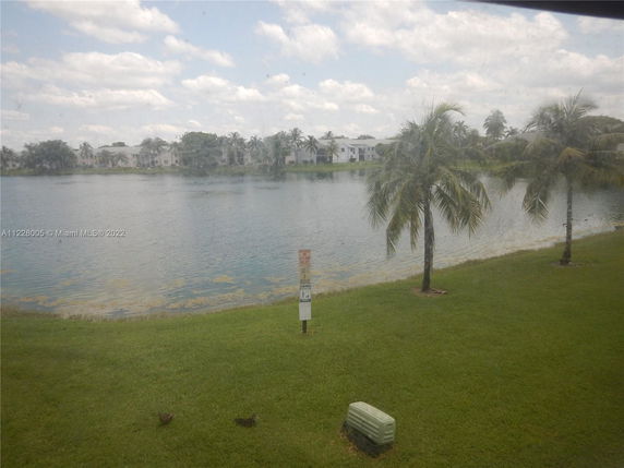 View from a distance of houses across a lake with palm trees.