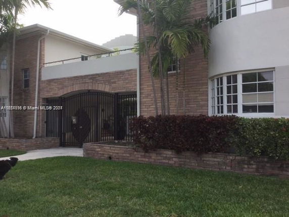 Front view of a multi-story house with brick and stucco facade.
