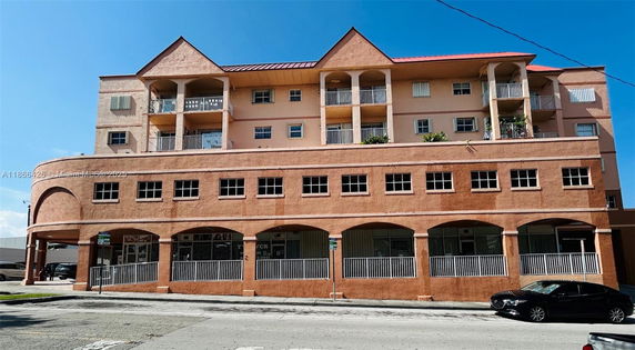 Front view of a multi-story building with arched windows and balconies.