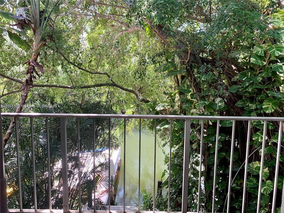 View of lush green surroundings and a body of water from a balcony.